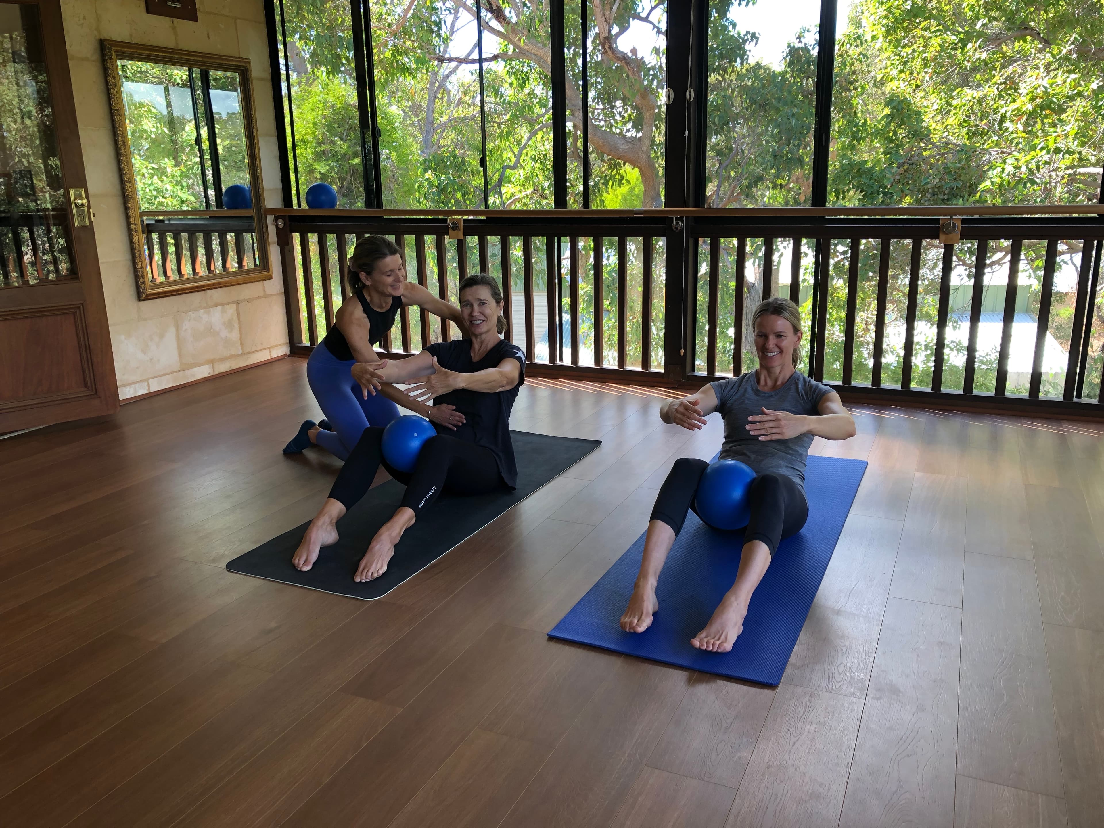 Teacher correcting students in fit ball exercise